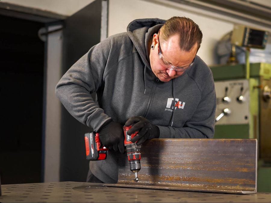 Mitarbeiter bei der Konstruktion und Fertigung eines Metallbauteils
