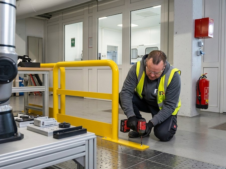 PRIMA4U-Techniker montiert eine nach Maß gefertigte Schutzkonstruktion aus Metall direkt vor Ort beim Kunden